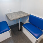 Corner booth table with blue seats in medical specialty vehicle