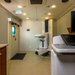 Interior of mammography motor coach with computer, table, door, and machine