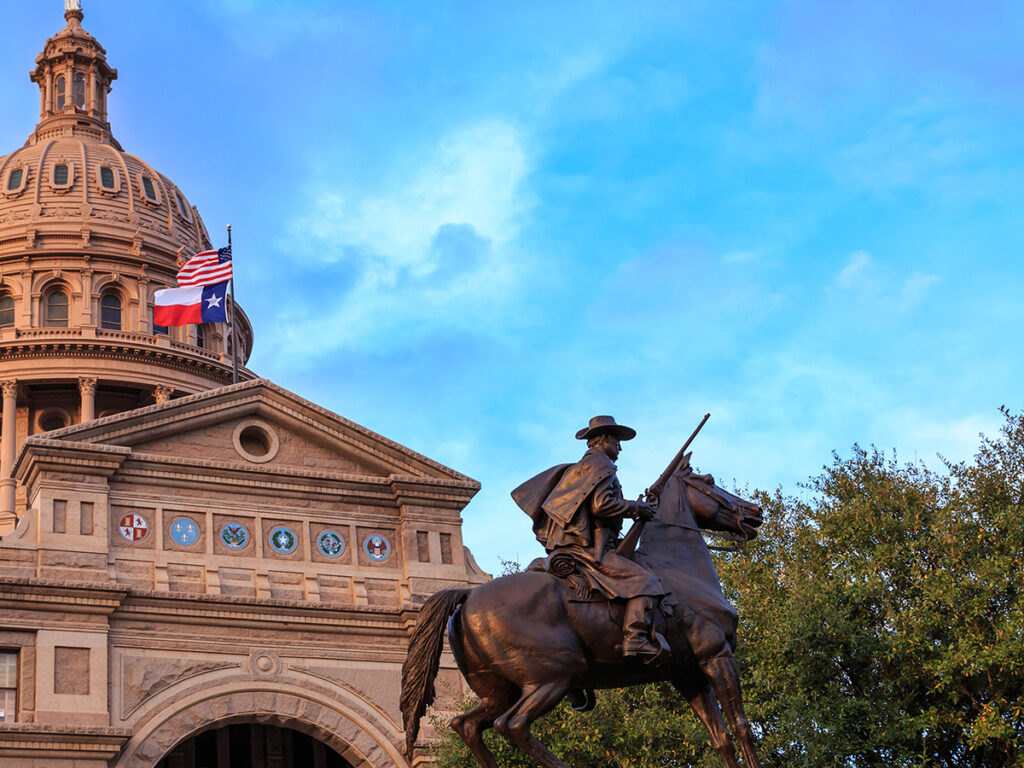 Image of the Texas Ranger Statue in front of the Texas Capitol building in Austin, TX