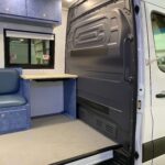 Looking into a Sprinter mobile medical vehicle through the side door to see blue cabinets, countertop, and bulkhead