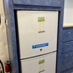 Interior of a Sprinter healthcare van, looking at two white medical fridges