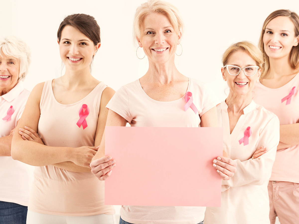 A group of multi-generational women in pink with breast cancer ribbons on