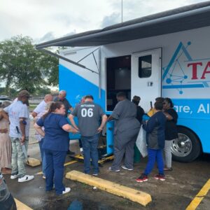 Nurses and patients looking at a mobile health clinic